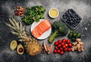 An image of a collection of healthy foods including salmon pineapple and avocado