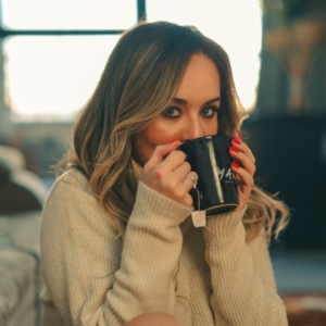 An image of a woman drinking a soothing cup of lemon and honey tea