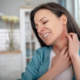 a woman not understanding throat irritants scratching her throat