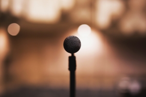 An image of a microphone against a blurred background of lights