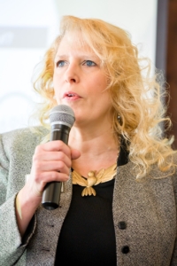 An image a a woman speaking into a microphone