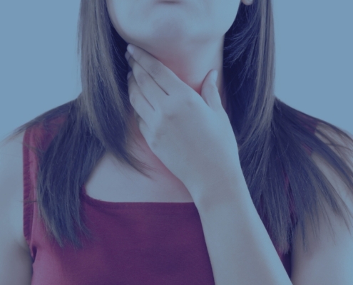 An image of a woman with a throat disorder holding her throat.