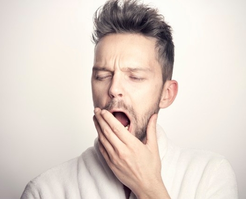 Man yawning with hand over his mouth