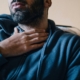 man holding neck seeking optimal throat health